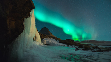 Icy landscape with Northern Lights in sky